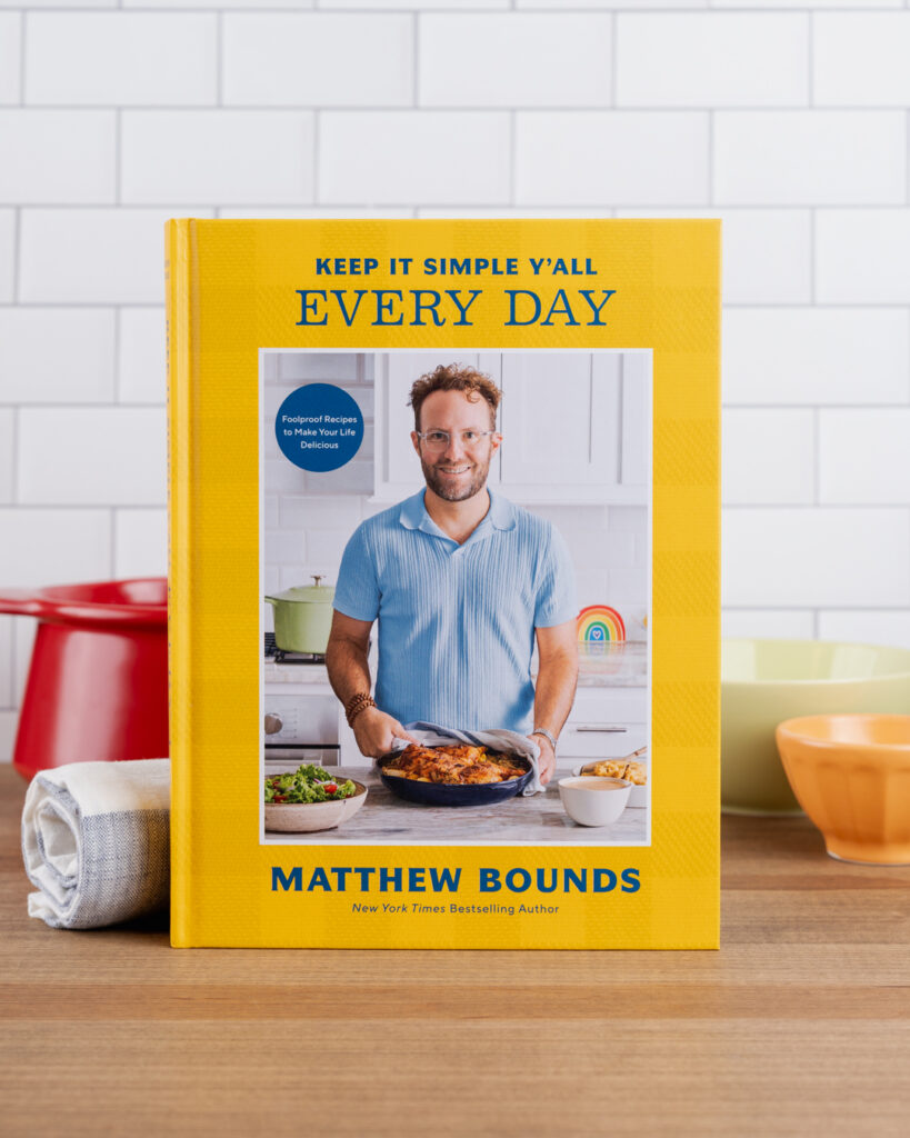 Keep It Simple Y'all Every Day, book by Matthew Bounds, sits on a counter next to cooking utensils.