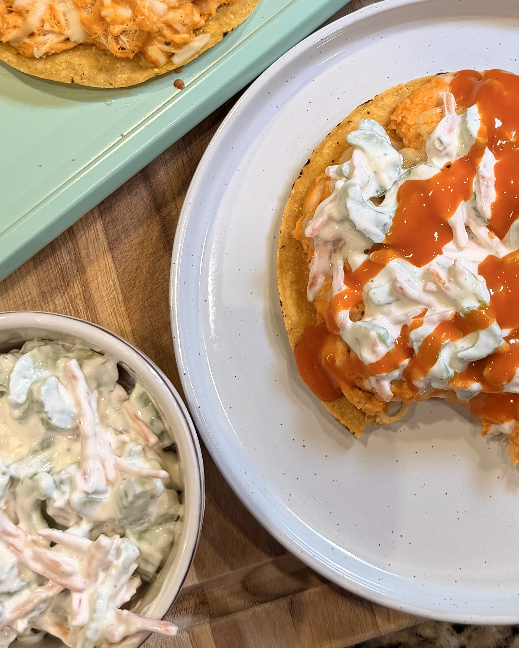 Buffalo chicken tostadas and creamy celery slaw on a plate