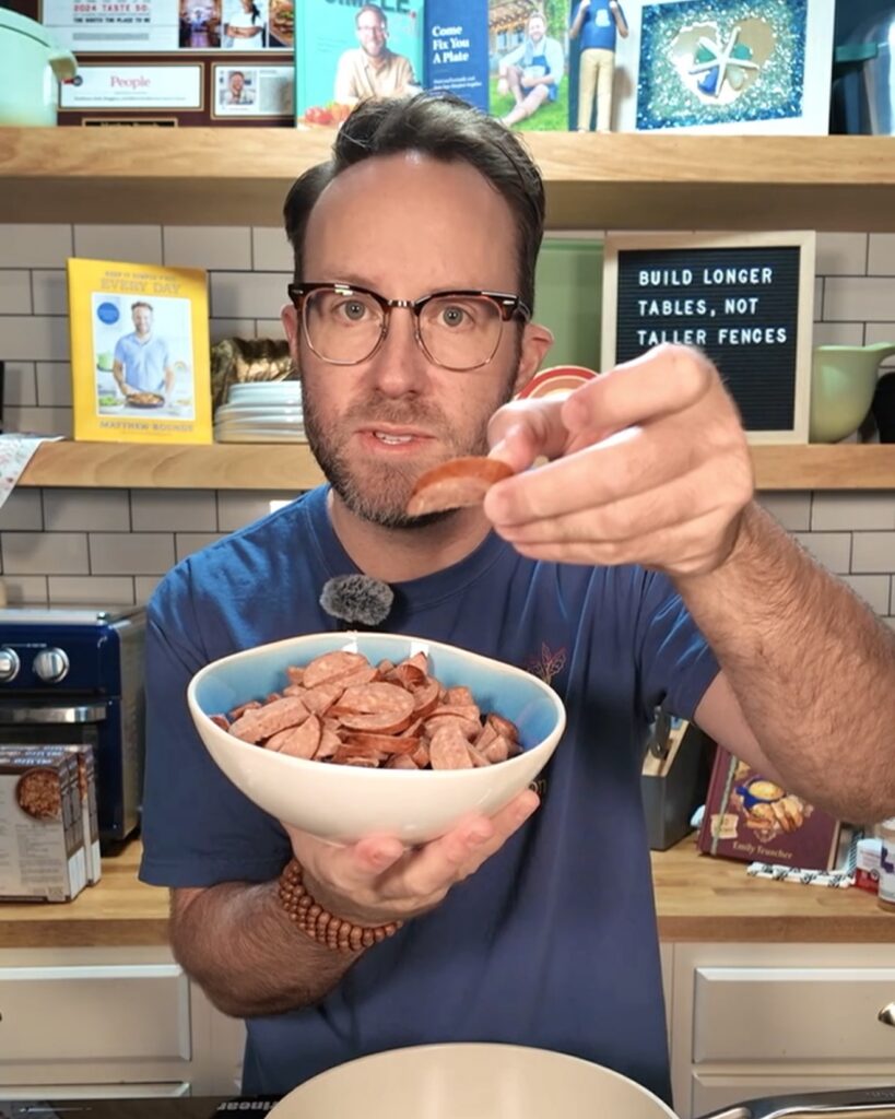 Matthew holding a bowl of sausage