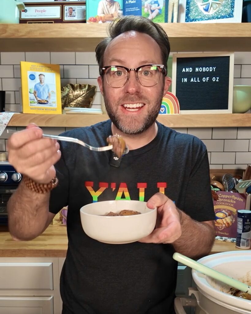 Your Barefoot Neighbor Matthew Bounds holds a bowl of Crockpot Italian Beef and Gravy in his kitchen