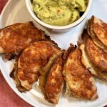 Crockpot pork street tacos on a plate with a side of guacamole