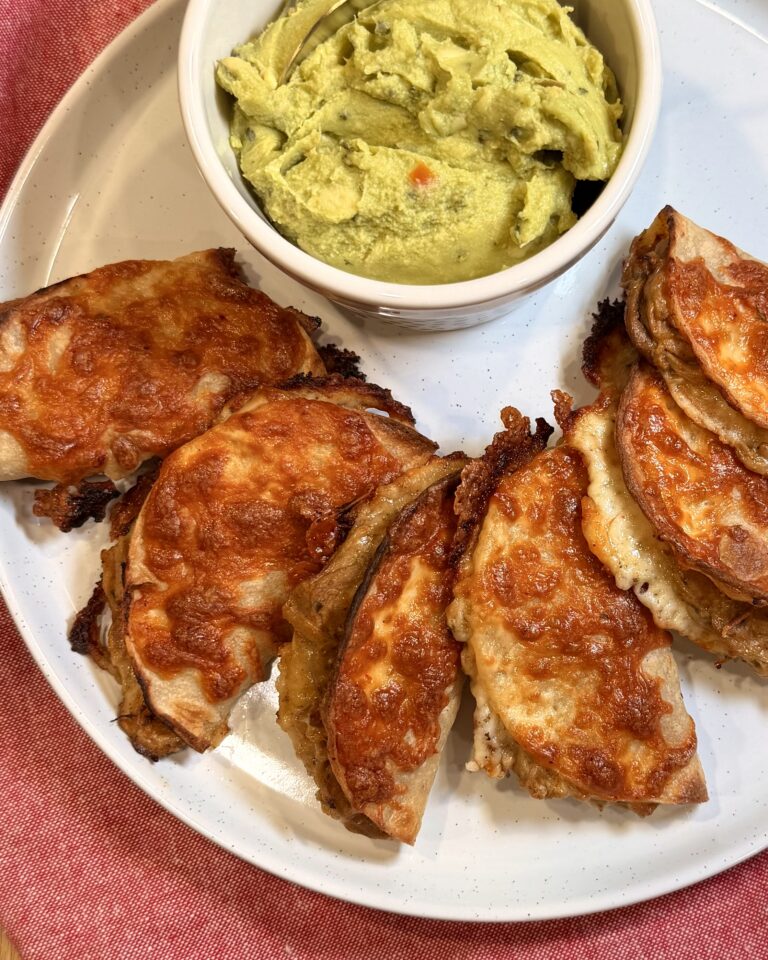 Crockpot pork street tacos on a plate with a side of guacamole