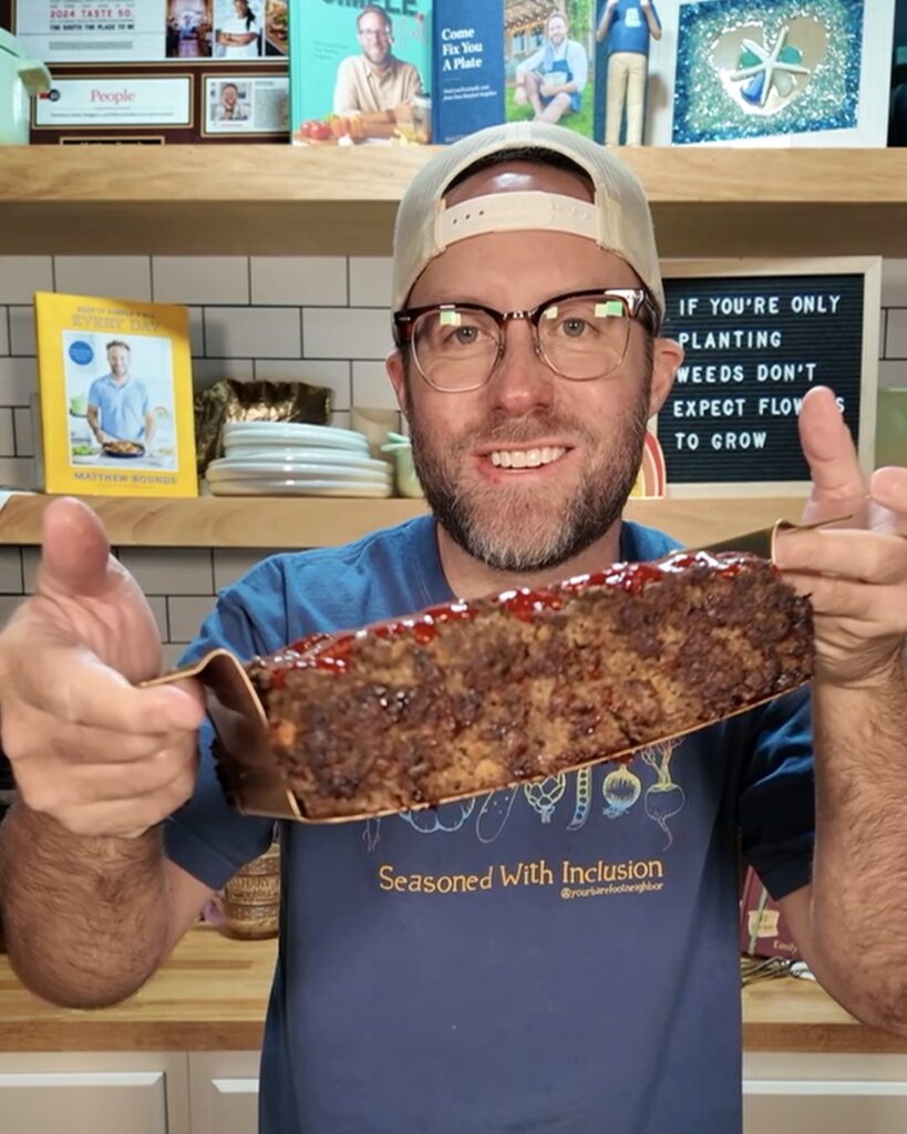 Your Barefoot Neighbor Matthew Bounds holding a meatloaf in his kitchen from cookbook Keep It Simple Everyday