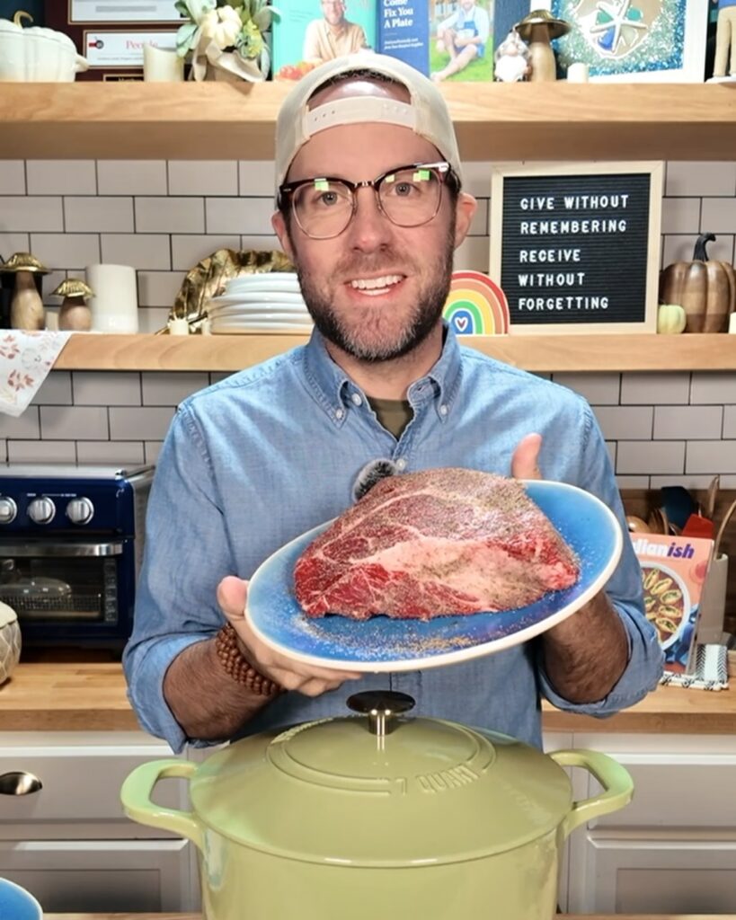 Your Barefoot Neighbor Matthew Bounds holding a roast in his kitchen for Keep It Simple Y'all Everyday Cookbook recipe.