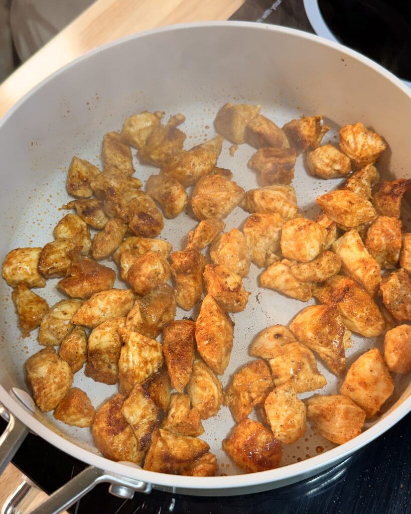 Chicken sautéing in a pan on the stove for Lemony Parmesan Chicken with Orzo dish