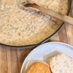 Your Barefoot Neighbor Matthew Bounds's Sausage Gravy bubbles in a skillet next to freshly baked biscuits