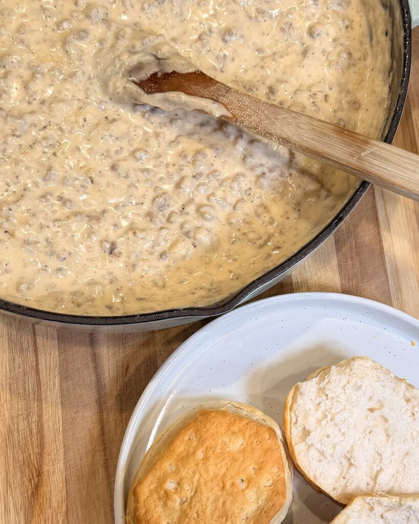 Your Barefoot Neighbor Matthew Bounds's Sausage Gravy bubbles in a skillet next to freshly baked biscuits