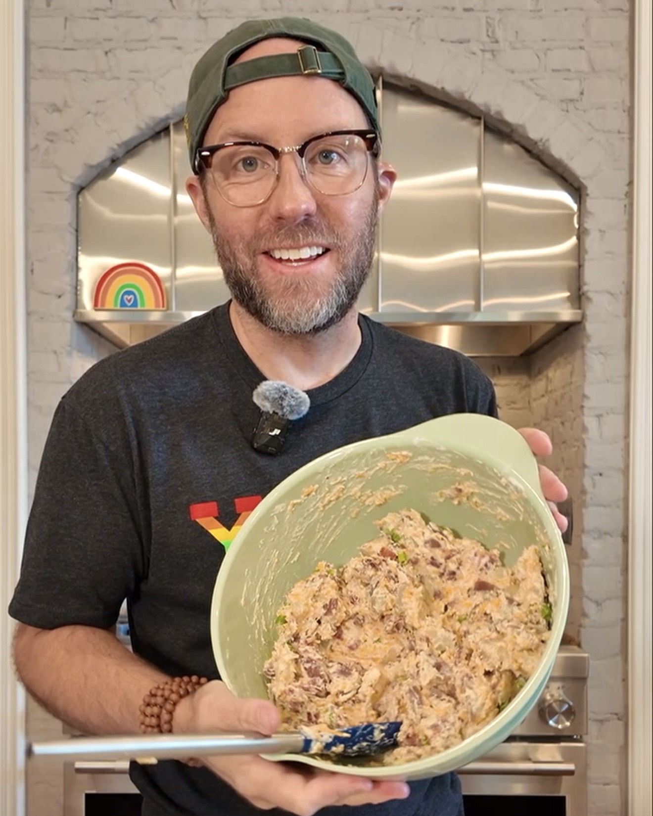 Matthew Bounds, creator of Your Barefoot Neighbor and author of Keep It Simple Y'all Every Day, holds a bowl of loaded baked potato salad in his ktichen.