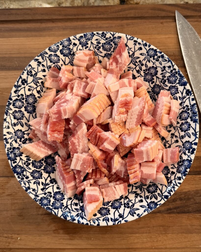 Sliced bacon sits in a bowl before it's added to the skillet to cook for Cheesy Bacon Chicken and Brussels Sprouts cooked by Your Barefoot Neighbor Matthew Bounds.