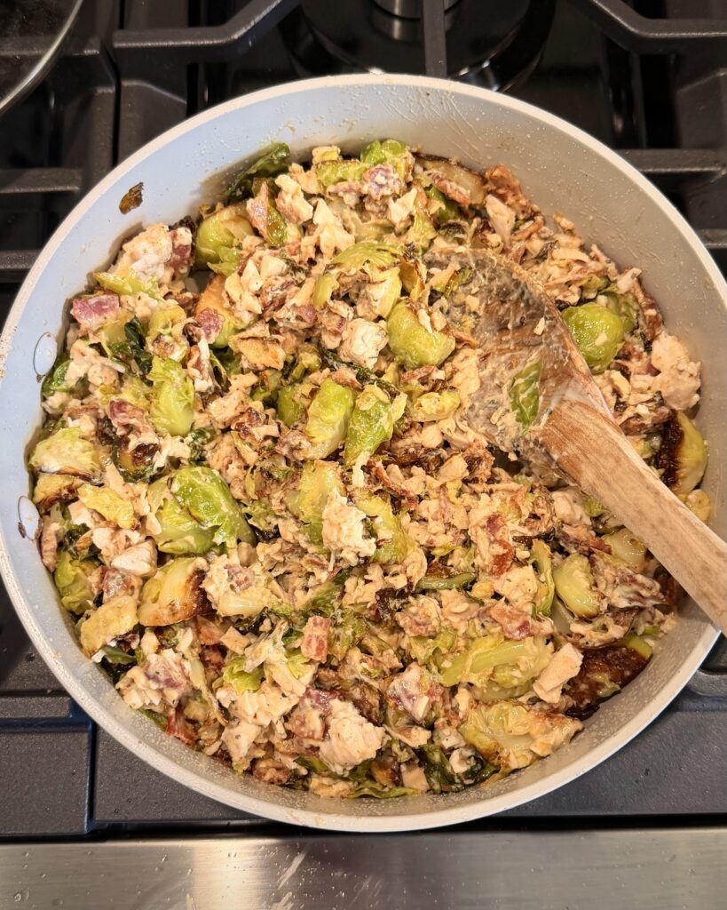 A portion of Cheesy Bacon Chicken and Brussels Sprouts cooked by Your Barefoot Neighbor Matthew Bounds cooks in a skillet.