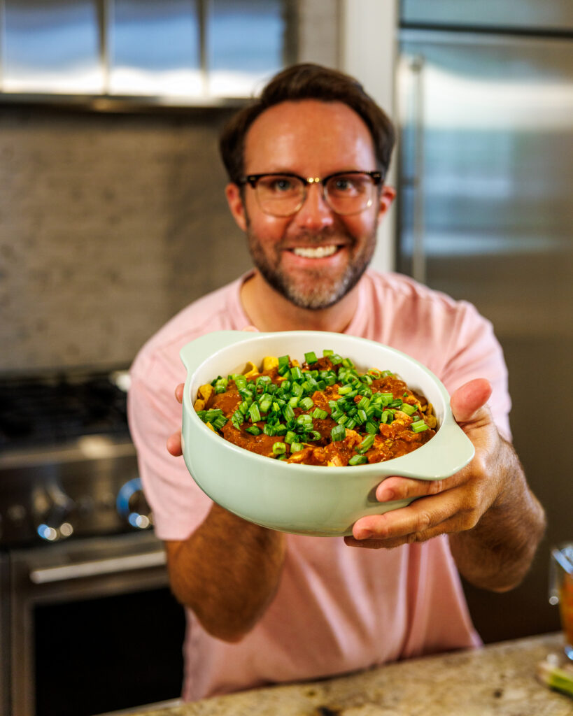 Matthew Bounds, creator of Your Barefoot Neighbor, holds a hearty bowl of Chili Frito Pie
