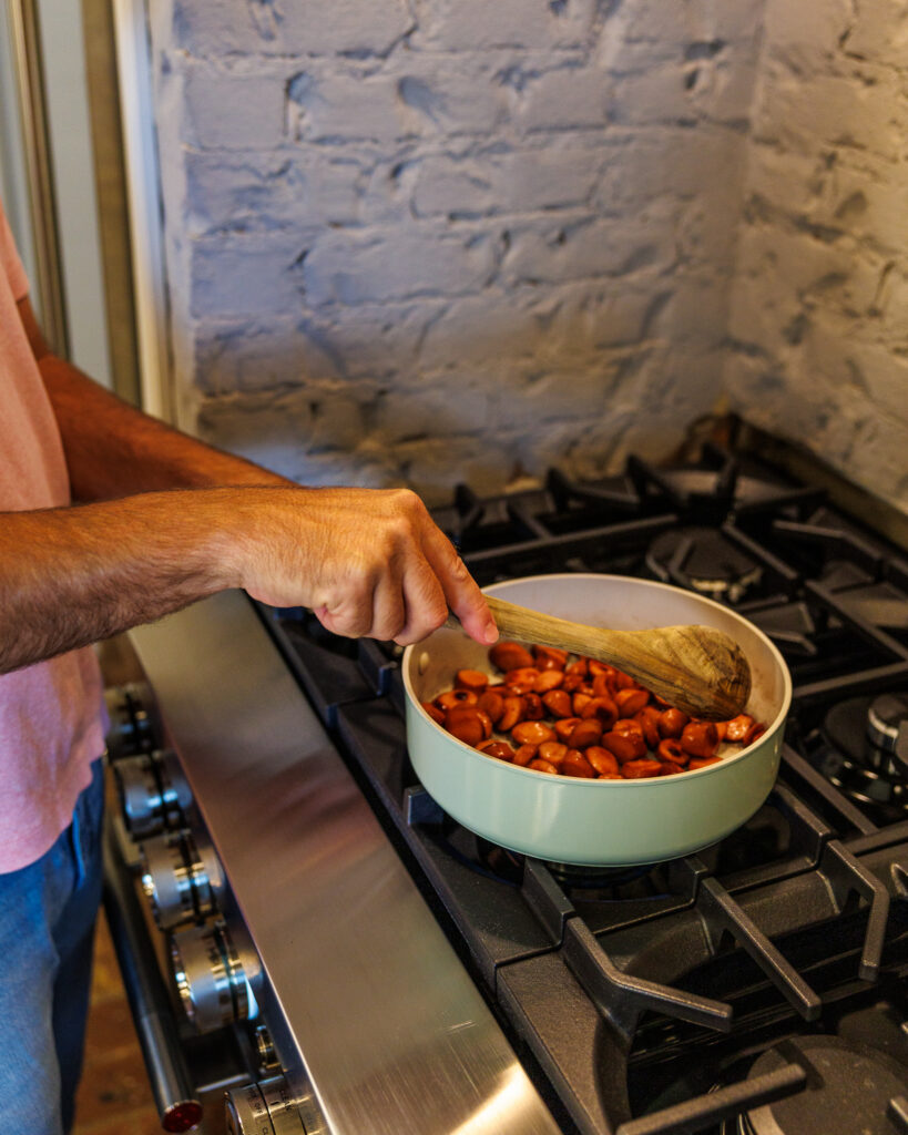 Matthew Bounds, creator of Your Barefoot Neighbor, browns the sliced hot dogs for his easy Corndog Casserole