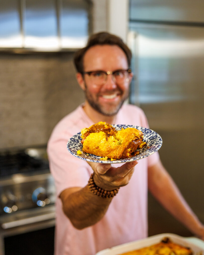 Your Barefoot Neighbor holds a plate of his easy Corndog Casserole