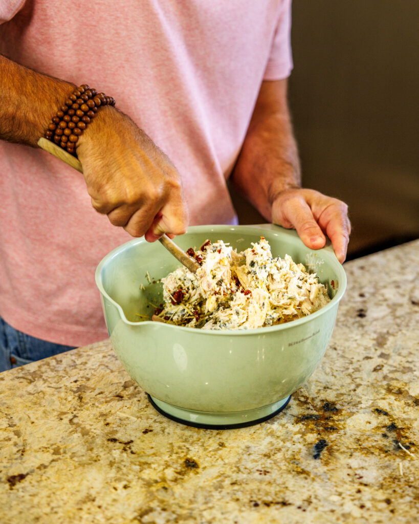 Matthew Bounds, creator of Your Barefoot Neighbor, mixes the creamy and savory ingredients for his Marry Me Chicken Sliders in a bowl