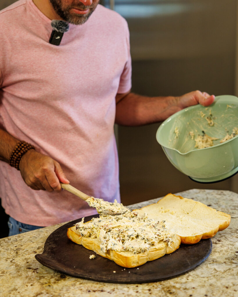 Matthew Bounds, creator of Your Barefoot Neighbor, spreads the spinach artichoke and chicken mixture on his Marry Me Chicken Sliders