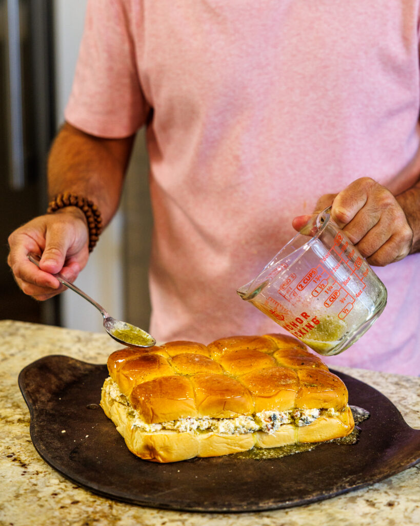 Matthew Bounds, creator of Your Barefoot Neighbor, drizzles seasoned butter on his Marry Me Chicken Sliders