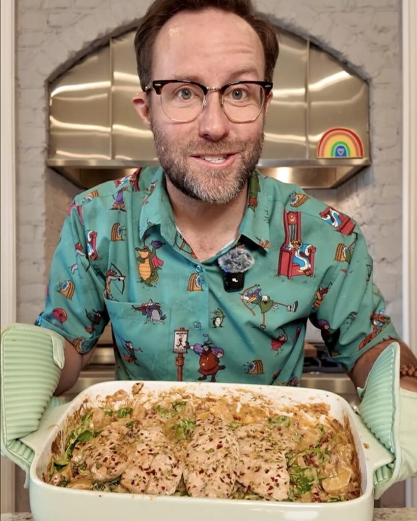 Matthew Bounds, creator of Your Barefoot Neighbor, holds a pan of creamy Spinach Alfredo Potatoes and Chicken