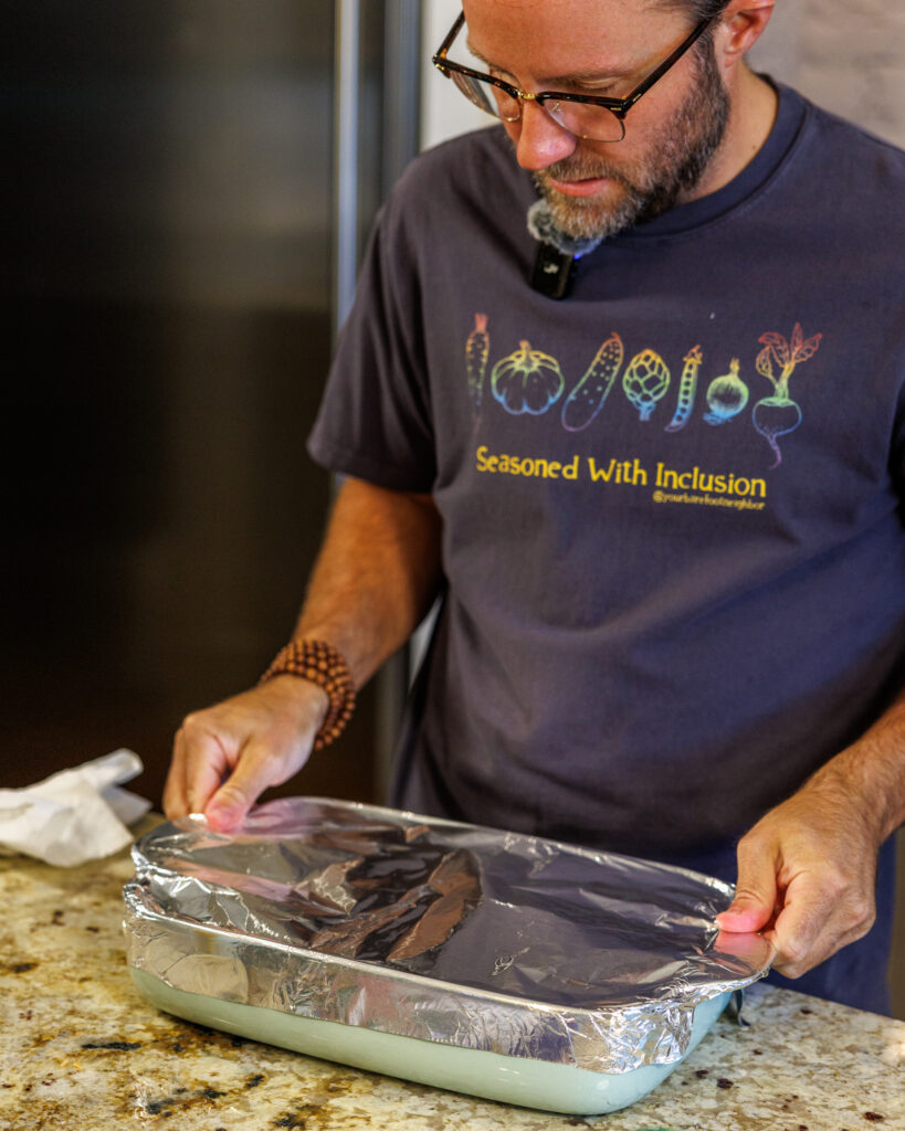 Your Barefoot Neighbor Matthew Bounds adds ingredients puts aluminum foil on his Baked Swim Queso Chicken dish
