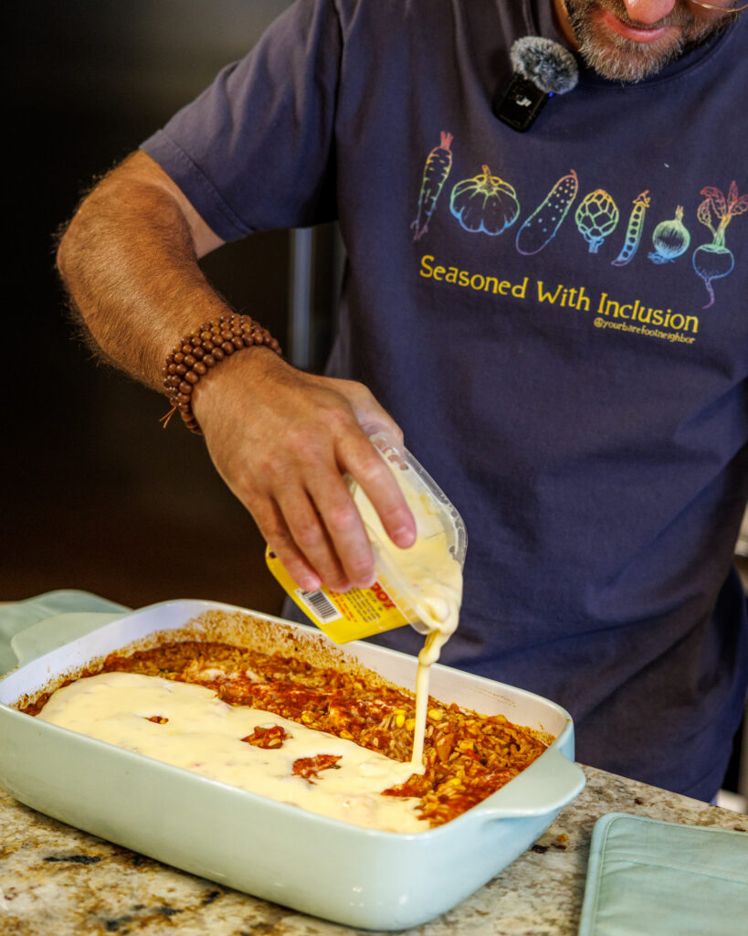 Your Barefoot Neighbor Matthew Bounds adds queso to the top of his dish for his Baked Swim Queso Chicken 