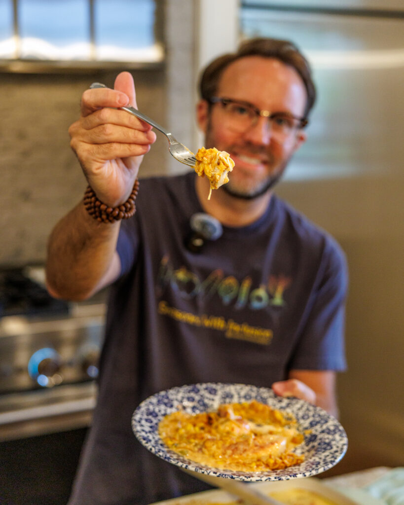 Matthew Bounds, creator of Your Barefoot Neighbor, holds a plate of Baked Swim Queso Chicken