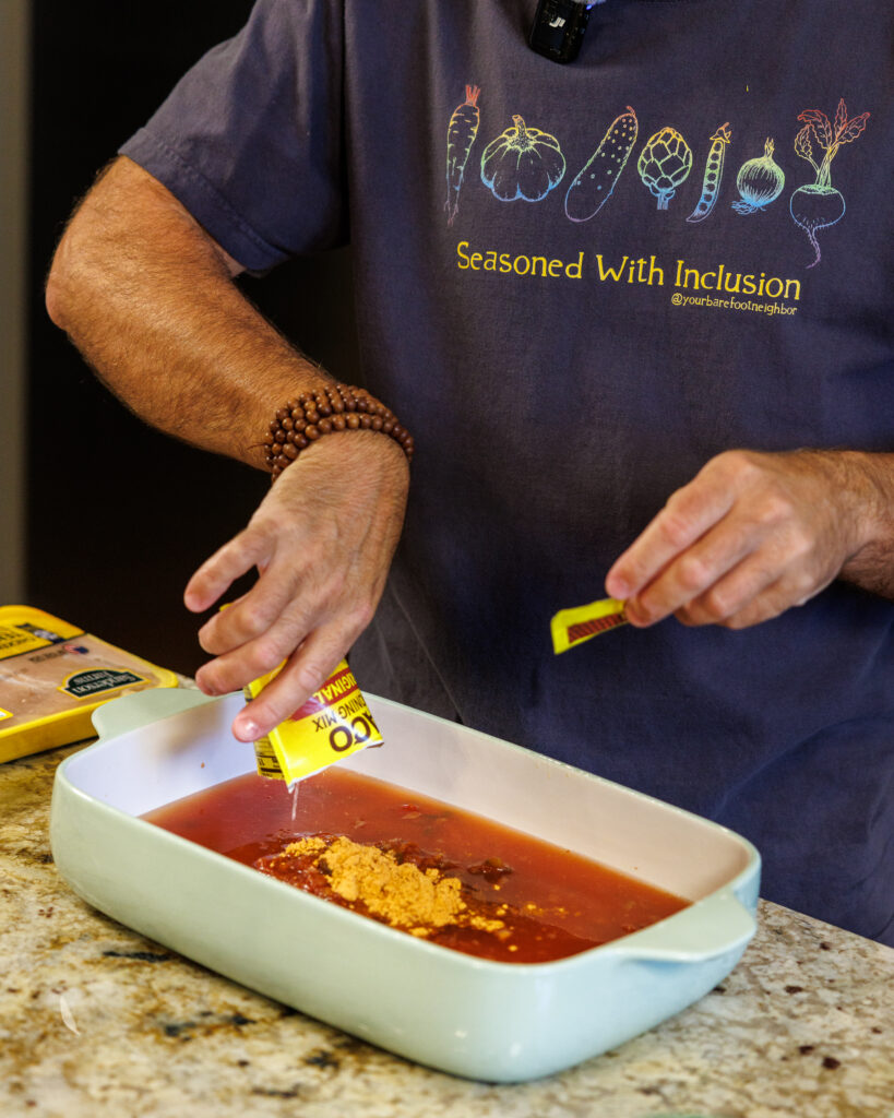 Your Barefoot Neighbor Matthew Bounds adds ingredients to his dish for his Baked Swim Queso Chicken in his kitchen