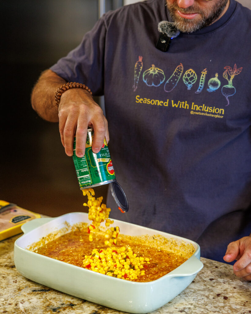 Your Barefoot Neighbor Matthew Bounds adds ingredients to his dish for his Baked Swim Queso Chicken in his kitchen