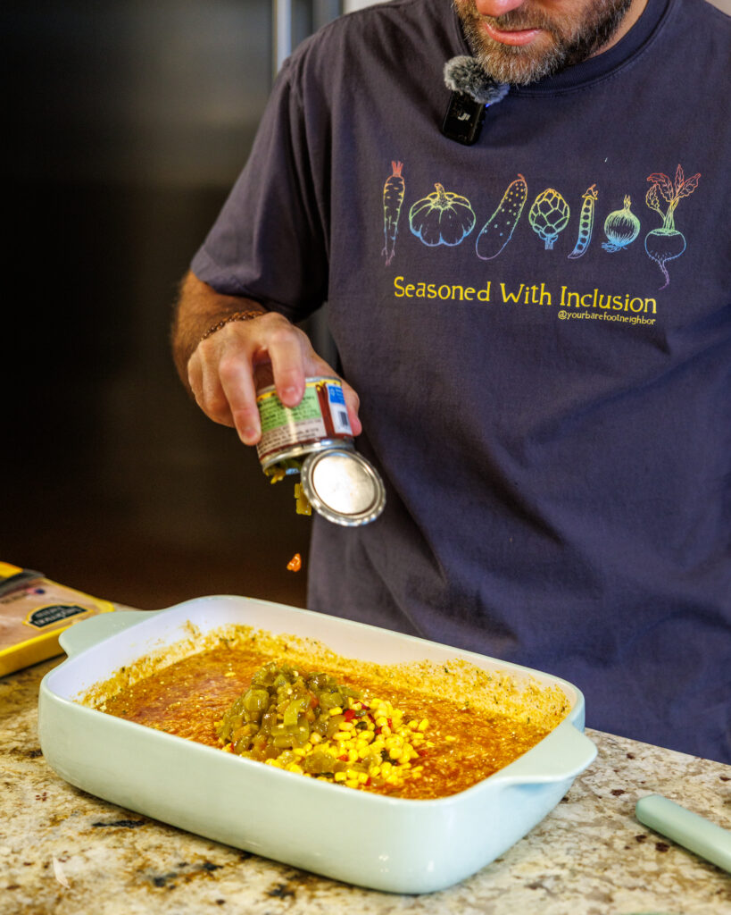 Your Barefoot Neighbor Matthew Bounds adds ingredients to his dish for his Baked Swim Queso Chicken in his kitchen
