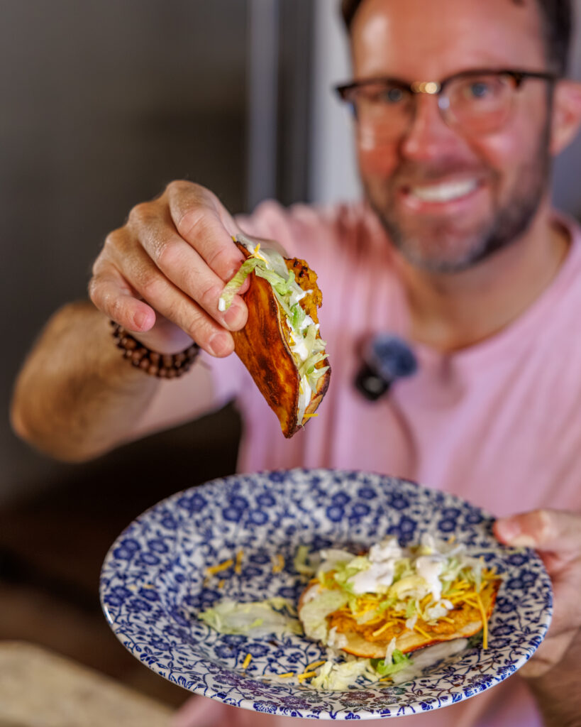 Matthew Bounds, creator of Your Barefoot Neighbor, holds a Buffalo Chicken Smash Taco