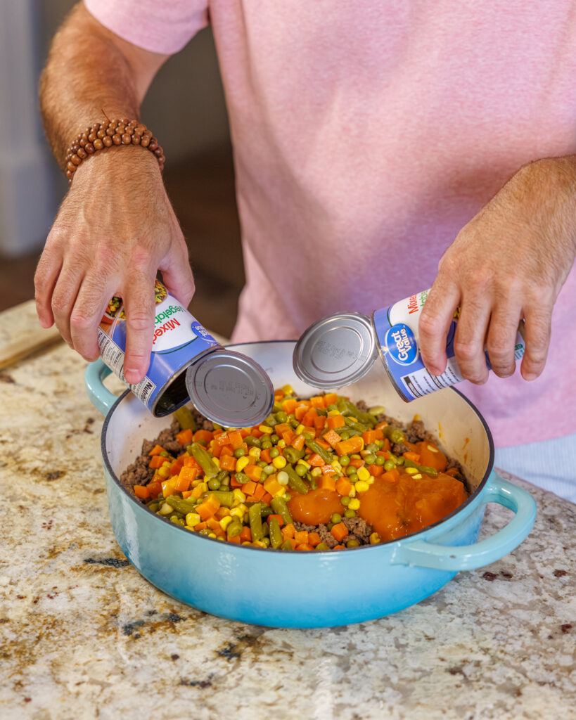 Matthew Bounds, creator of Your Barefoot Neighbor, adds ingredients to his Cheddar Biscuit Beef Pie from Keep It Simple Y'all Every Day