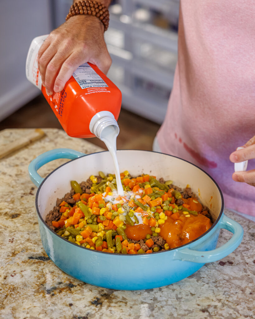 Matthew Bounds, creator of Your Barefoot Neighbor, adds ingredients to his Cheddar Biscuit Beef Pie from Keep It Simple Y'all Every Day