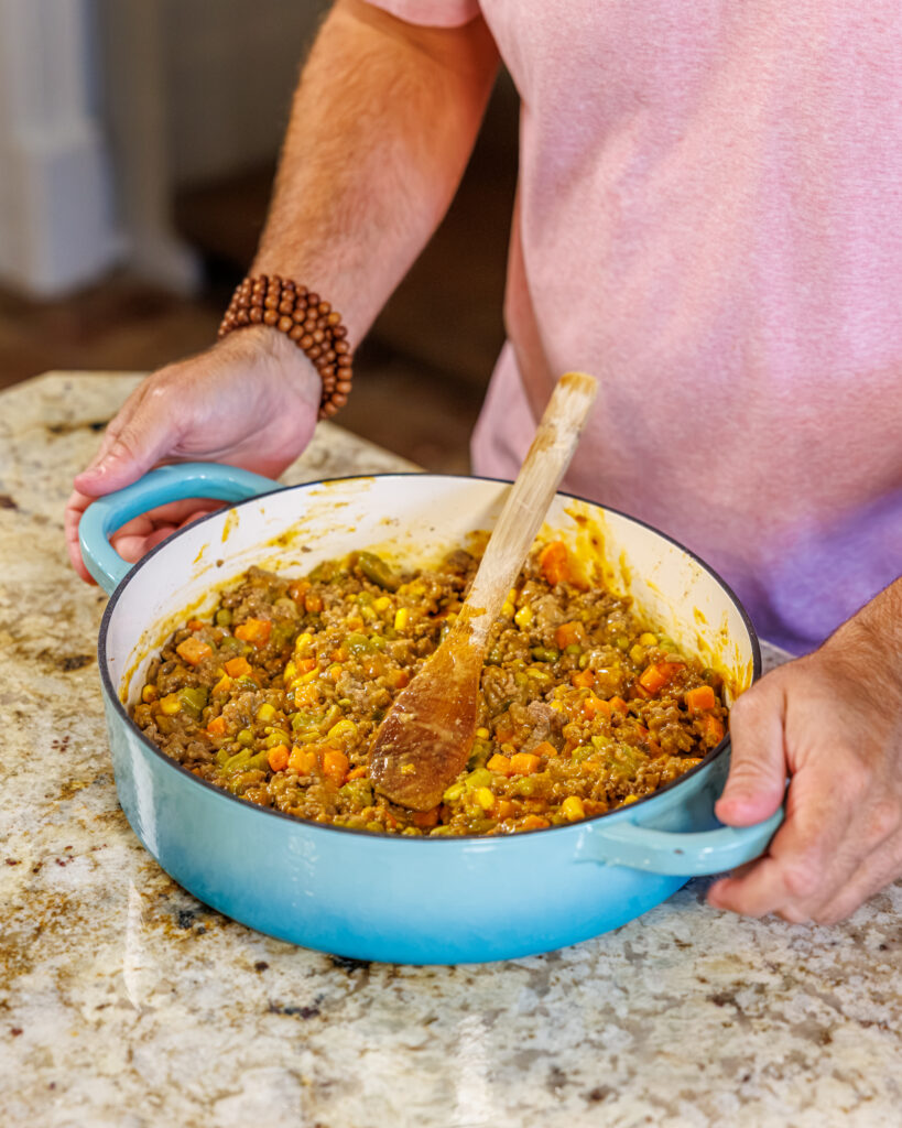 Matthew Bounds, creator of Your Barefoot Neighbor, mixes ingredients for his Cheddar Biscuit Beef Pie from Keep It Simple Y'all Every Day