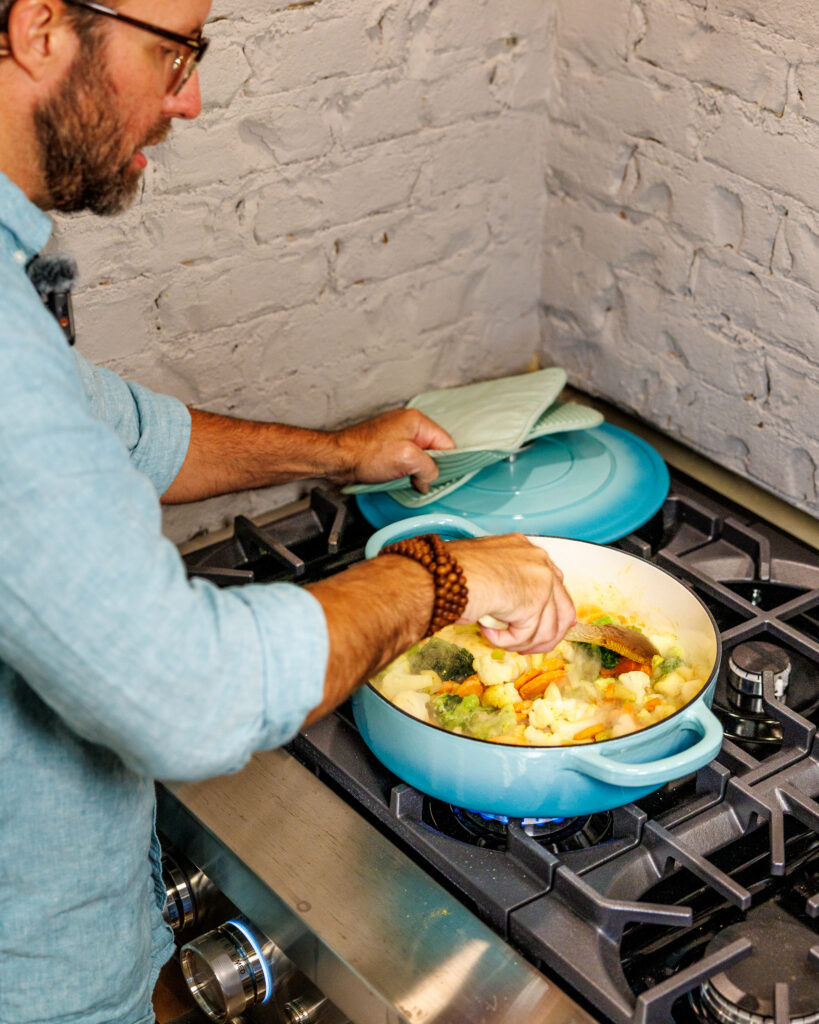 Matthew Bounds, creator of Your Barefoot Neighbor, add ingredients to his pot for Coconut Curry One Pot Chicken and Rice