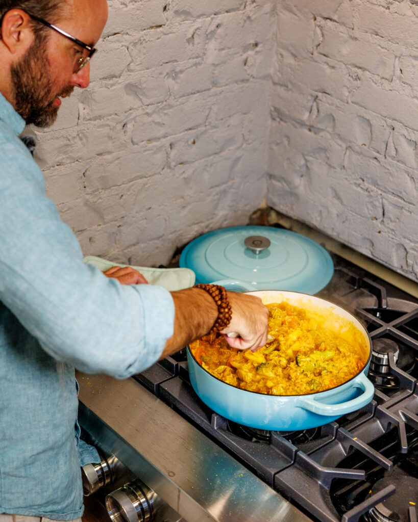 Matthew Bounds, creator of Your Barefoot Neighbor, add ingredients to his pot for Coconut Curry One Pot Chicken and Rice