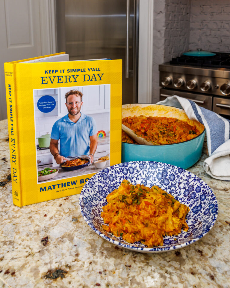 A bowl of Coconut Curry in a bowl on a counter next to Keep It Simple Y'all Every Day written by Matthew Bounds, creator of Your Barefoot Neighbor