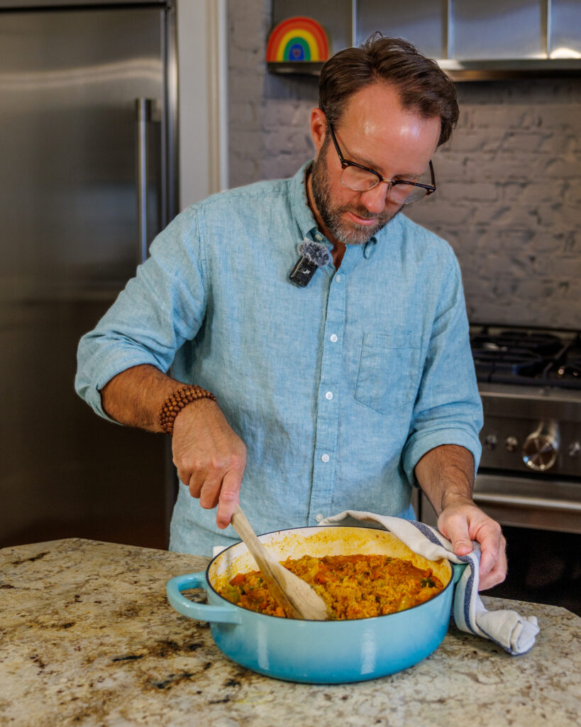 Matthew Bounds, creator of Your Barefoot Neighbor, stirs his Coconut Curry One Pot Chicken and Rice