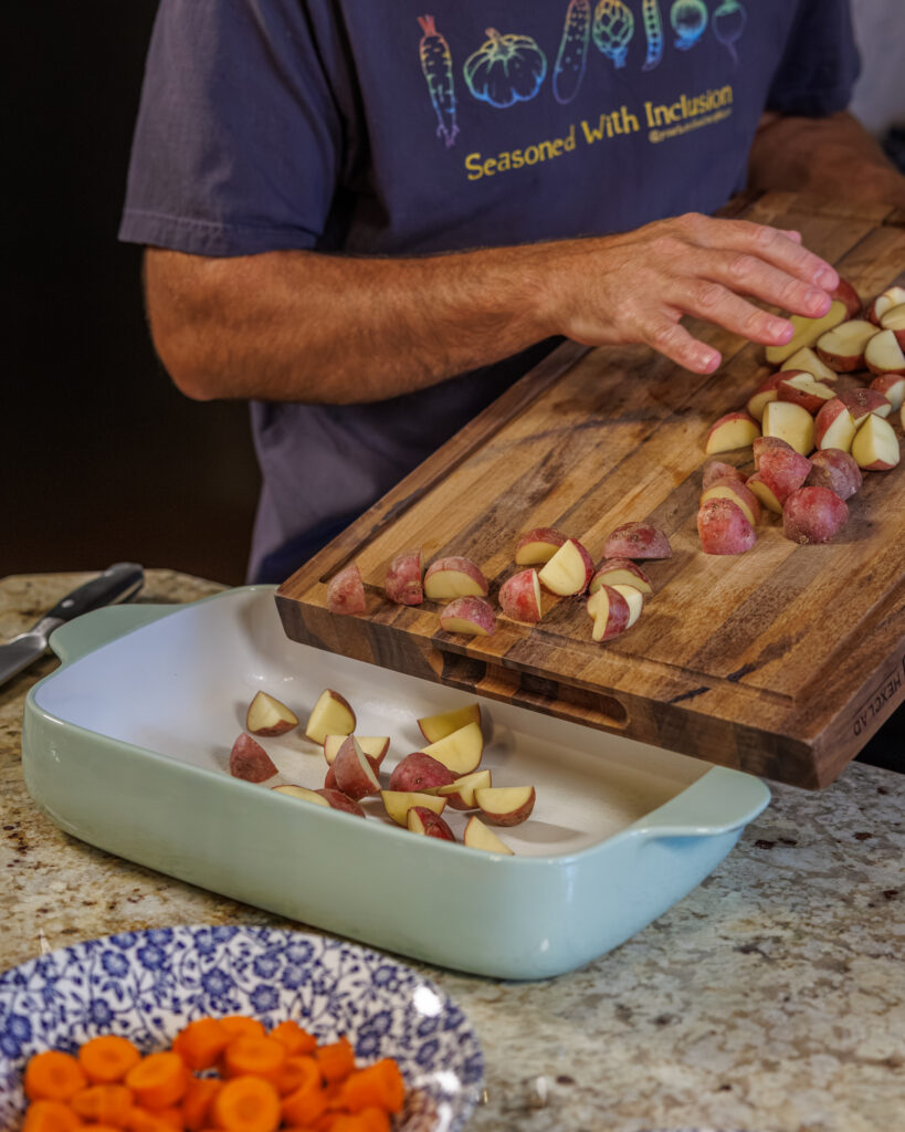 Matthew Bounds, creator of Your Barefoot Neighbor, pours chopped potatoes into a 9x13 dish for Hamburger Steaks and Gravy