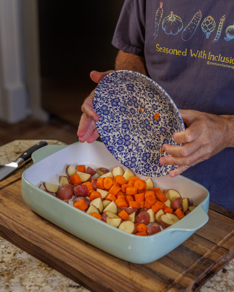 Matthew Bounds, creator of Your Barefoot Neighbor, pours chopped vegetables into a 9x13 dish for Hamburger Steaks and Gravy