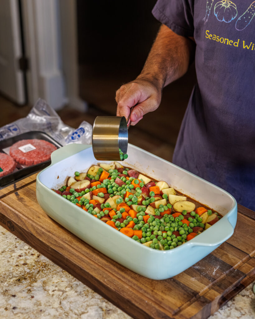 Matthew Bounds, creator of Your Barefoot Neighbor, pours gravy into a 9x13 dish for Hamburger Steaks and Gravy