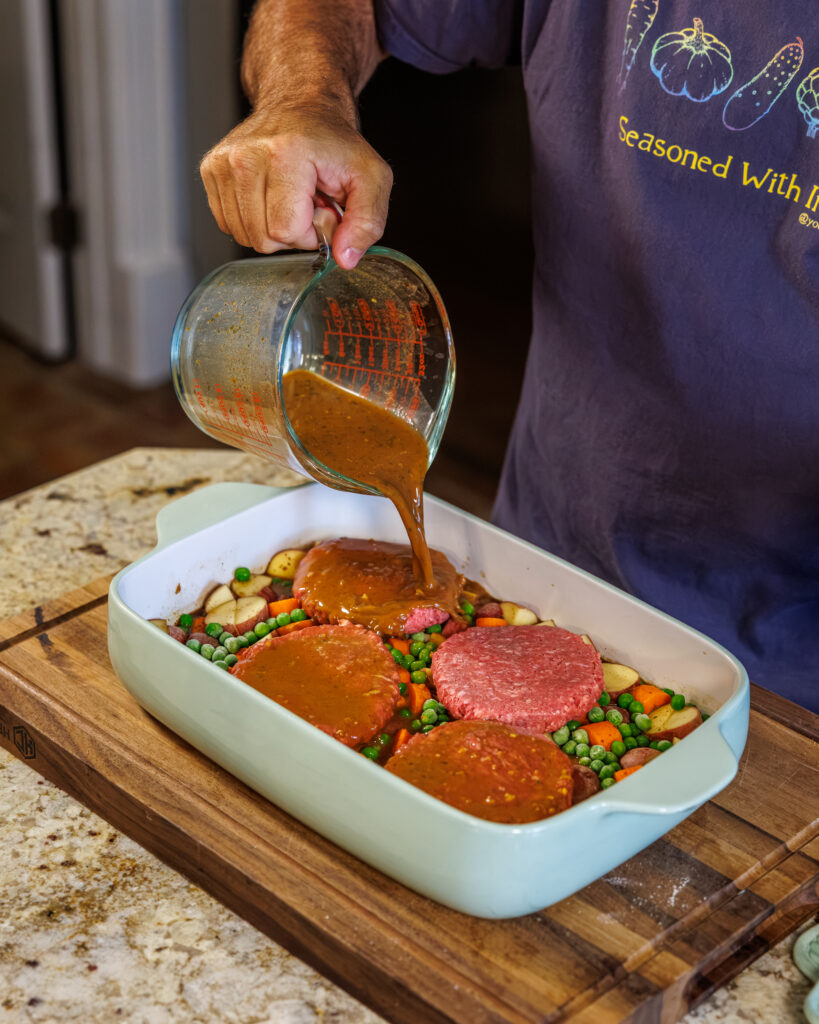 Matthew Bounds, creator of Your Barefoot Neighbor, pours gravy into a 9x13 dish for Hamburger Steaks and Gravy