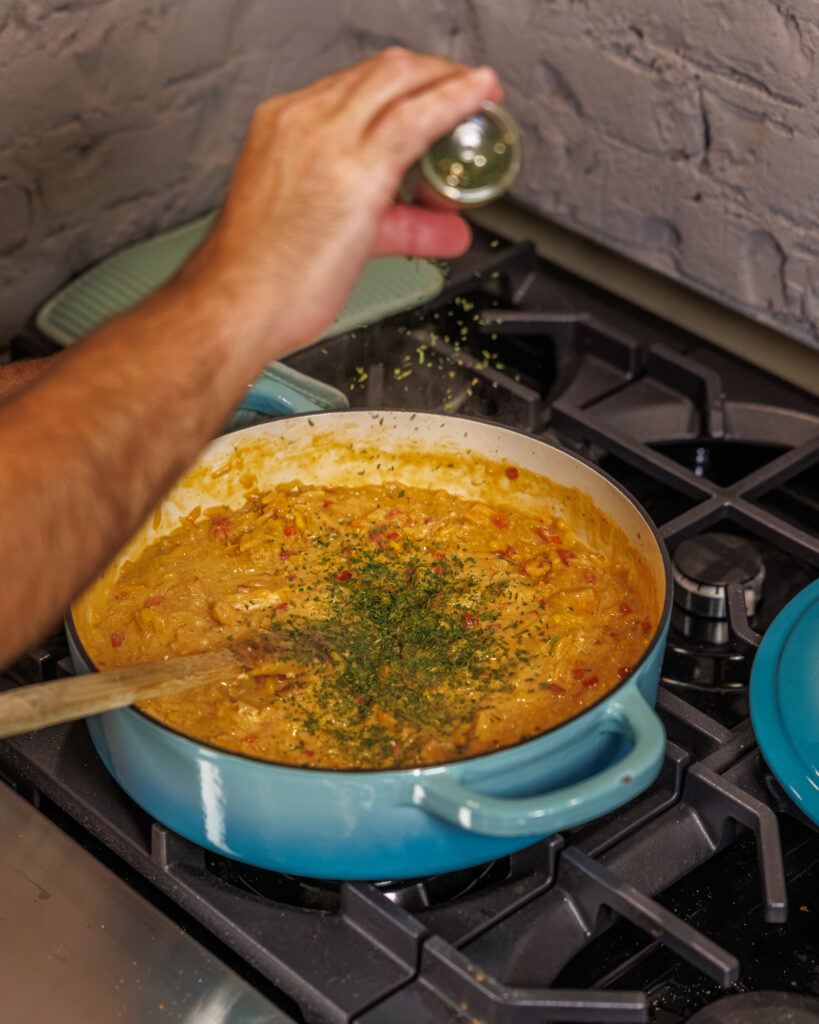 Matthew Bounds, creator of Your Barefoot Neighbor, adds finishing touches to his One Pot Corn & Pimento Orzo