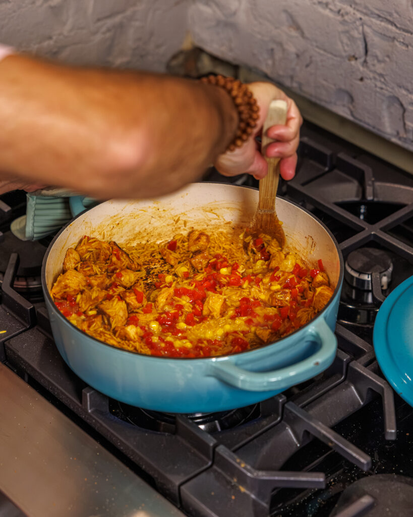 Matthew Bounds, creator of Your Barefoot Neighbor, add ingredients to his One Pot Corn & Pimento Orzo