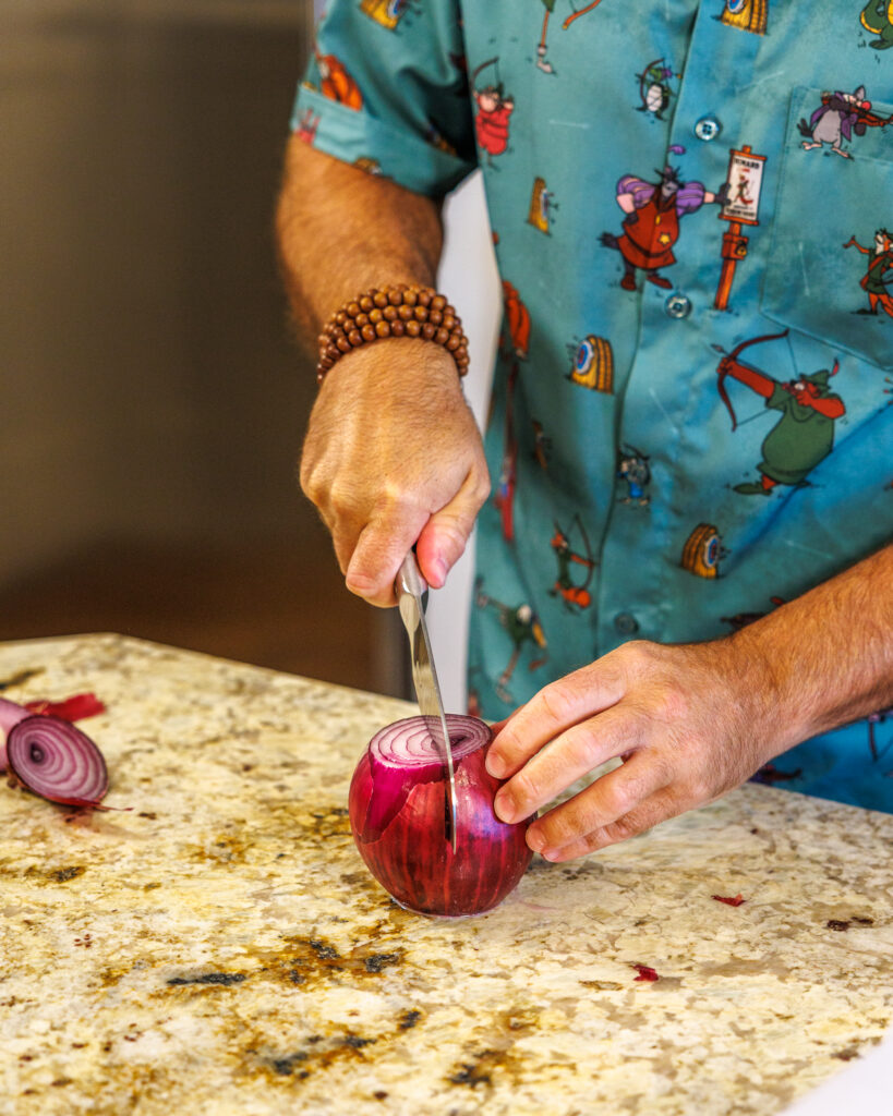 Matthew Bounds, creator of Your Barefoot Neighbor, chops vegetables for his Pizza Bubble Bake dish
