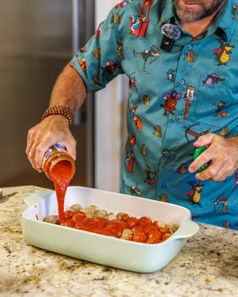 Matthew Bounds, creator of Your Barefoot Neighbor, adds sauce on top of vegetables for his Pizza Bubble Bake dish