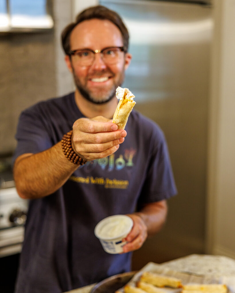 Matthew Bounds, creator of Your Barefoot Neighbor, holds one of his Shortcut Air Fryer Taquitos