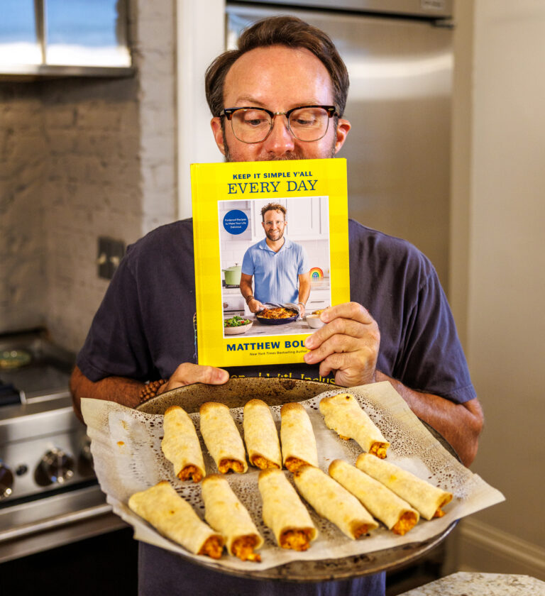 Matthew Bounds, creator of Your Barefoot Neighbor, holds his cookbook Keep It Simple Y'all Every Day above his Shortcut Air Fryer Taquitos