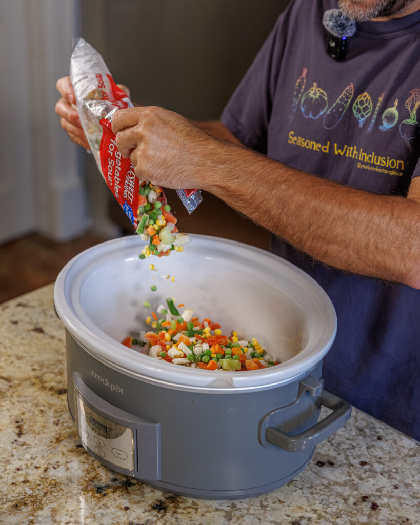 Matthew Bounds, creator of Your Barefoot Neighbor, adds vegetables to the slow cooker for his Slow Cooker Chicken & Gravy