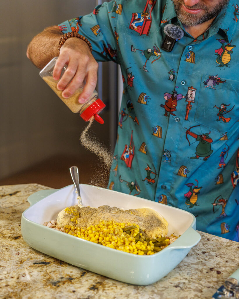 Matthew Bounds, creator of Your Barefoot Neighbor, adds ingredients to a 9x13 dish for his Tater Tot Chicken Casserole