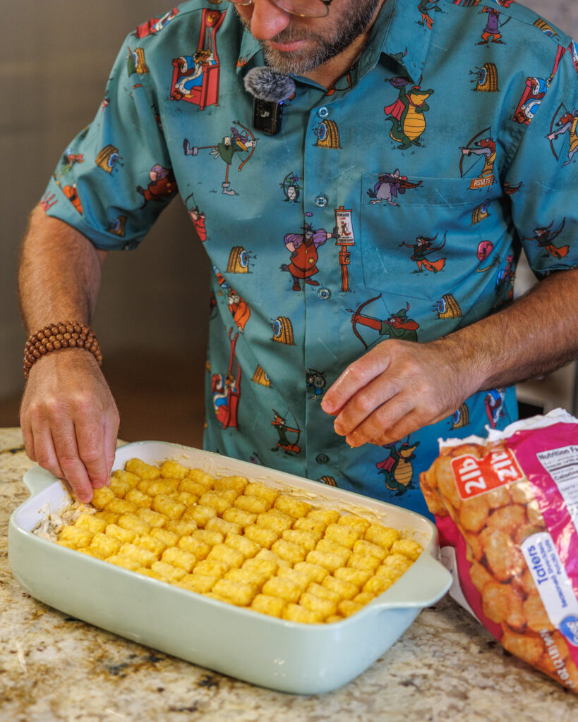 Matthew Bounds, creator of Your Barefoot Neighbor, adds ingredients to a 9x13 dish for his Tater Tot Chicken Casserole