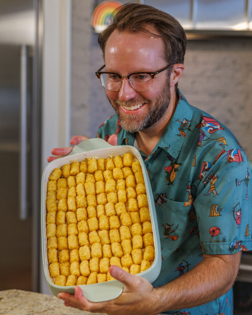 Matthew Bounds, creator of Your Barefoot Neighbor, holds a 9x13 dish with his Tater Tot Chicken Casserole before it goes in the oven