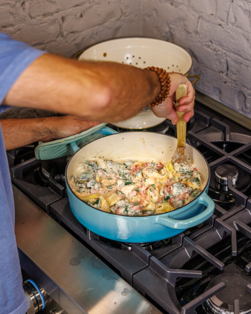 Matthew Bounds, creator of Your Barefoot Neighbor, adds ingredients to a pot for his Back to School Too Tired Tortellini